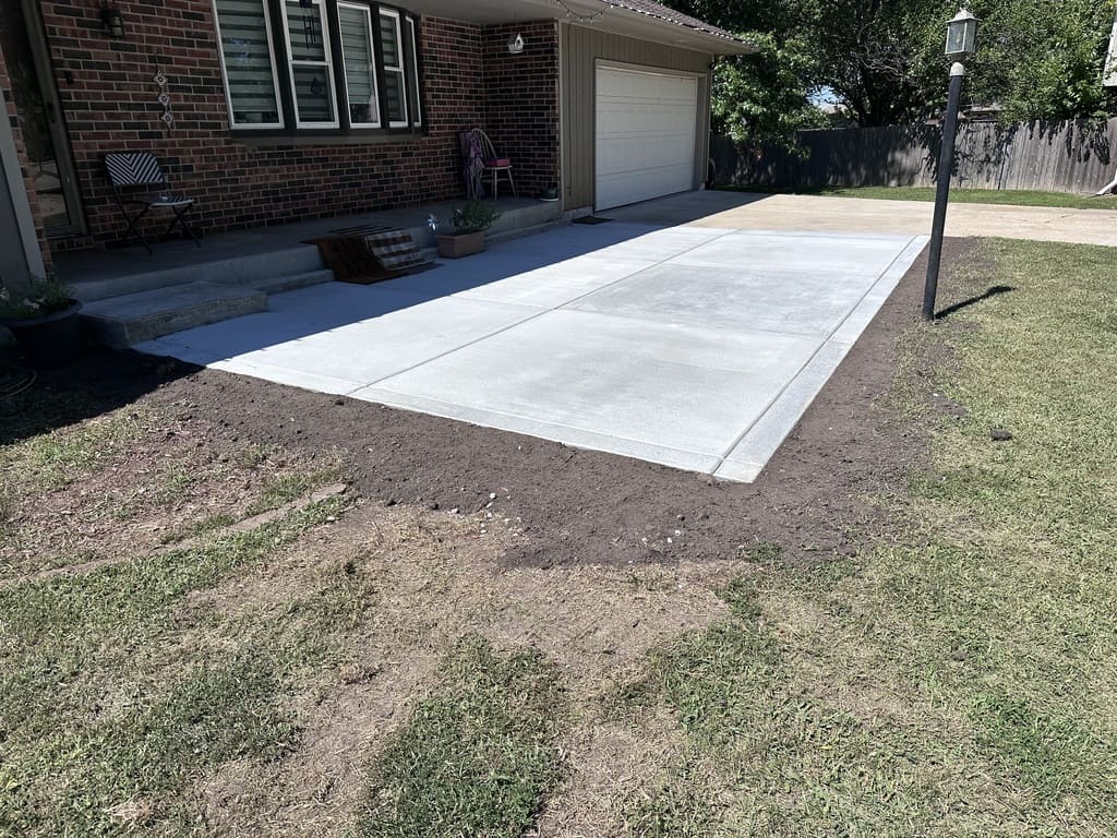 concrete slab extending from a sidewalk in the front yard of a house