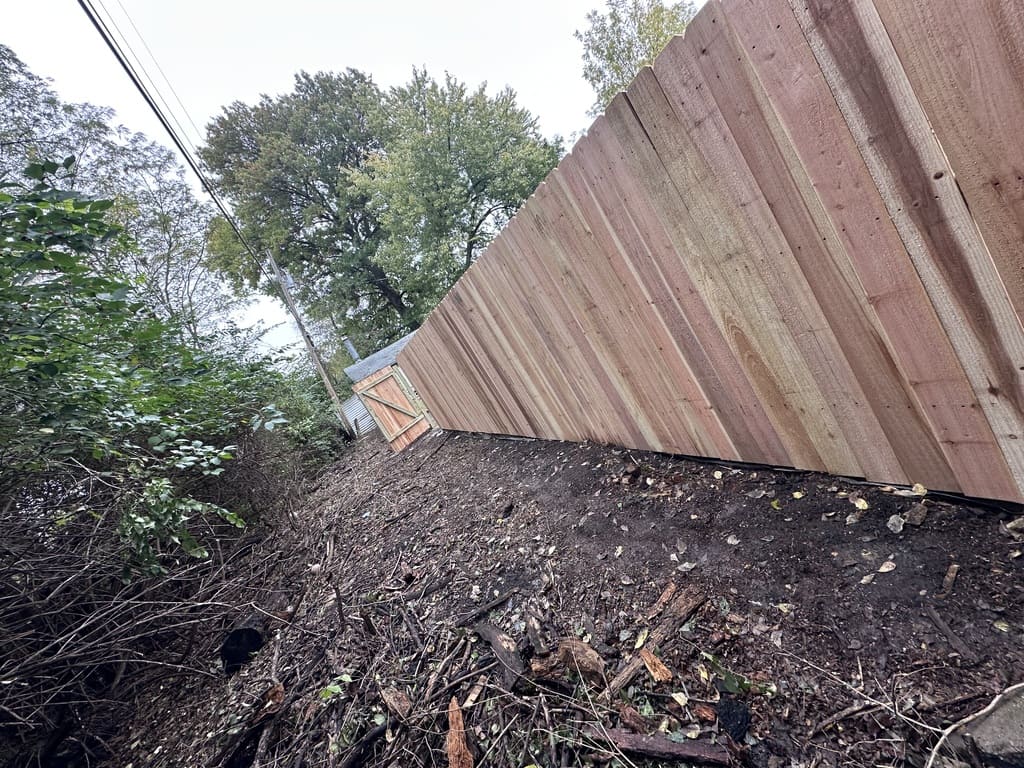 wood fence with dirt in front of it
